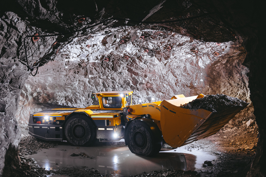 Caçamba amarela em mineração subterrânea, bem iluminada